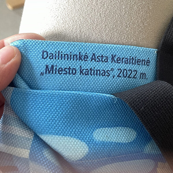 Dailininkė Asta Keraitienė, autorinis krepšys Miesto katinas, autoriniai krepšiai su paveikslo reprodukcija, riboto leidimo krepšiai, autorinės rankinės, krepšys su ilgomis rankenomis, krepšys su trumpomis rankenomis, dovana kačių mylėtojams, dovana miesto gerbėjams, aksesuarai su urbanistiniais motyvais, meniniai krepšiai, rankų darbo rankinės, rankinė su piešiniu, ak dirbtuvės, aksesuarai su paveikslo reprodukcijomis, aksesuarai su katinu, mėlynas krepšys, žydras krepšys